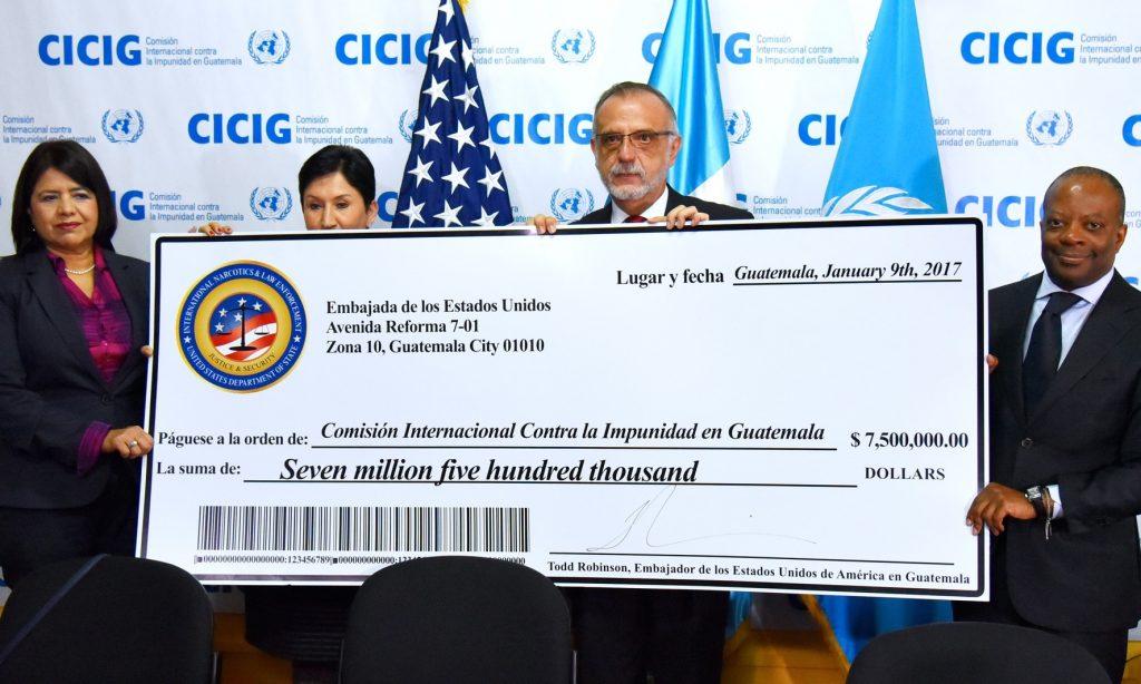 CICIG Commissioner Iván Velásquez holds the ceremonial check from the US embassy in Guatemala, with Ambassador Todd Robinson on the right. (US Embassy)