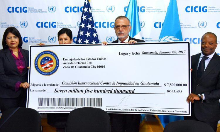 CICIG Commissioner Iván Velásquez holds the ceremonial check from the US embassy in Guatemala, with Ambassador Todd Robinson on the right. (US Embassy)